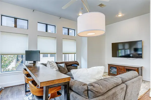 a living room with furniture a flat screen tv and a window