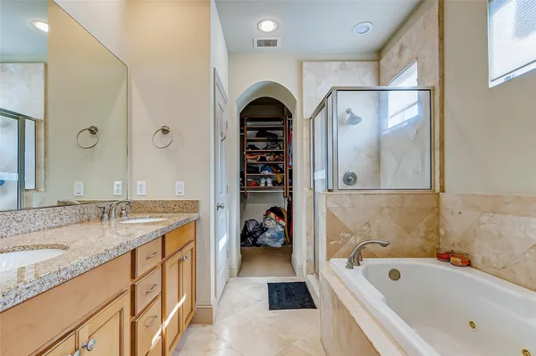 a bathroom with a granite countertop tub sink and mirror