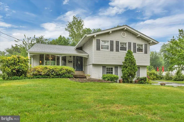 a front view of a house with a yard and trees