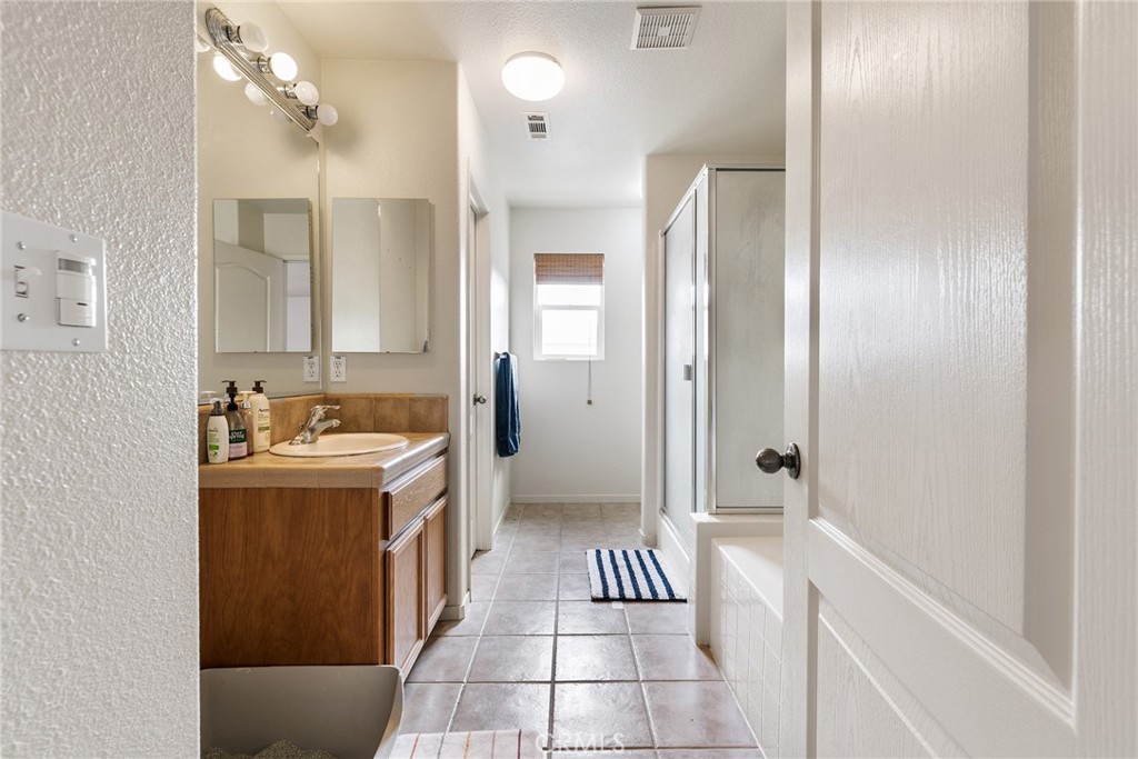 4357 Mathias Way Merced, CA 95348 - Photo 15 of 32 a bathroom with a granite countertop sink and a mirror