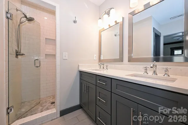 a bathroom with a double vanity sink mirror and shower