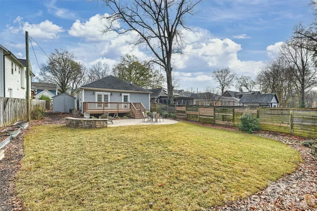 a view of a large pool with lawn chairs under an umbrella