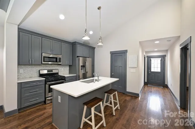 a kitchen that has a lot of cabinets a sink and appliances in it
