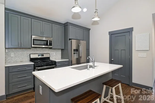 a kitchen with stainless steel appliances a stove a sink and a refrigerator