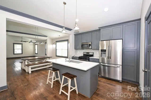 a kitchen with kitchen island a counter top space stainless steel appliances and cabinets