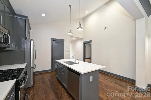 a kitchen with a sink a refrigerator a stove and white cabinets