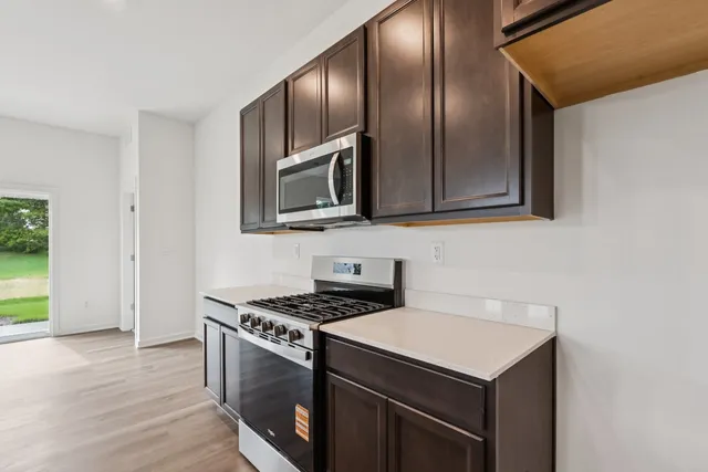 a kitchen with granite countertop cabinets stainless steel appliances and wooden floor