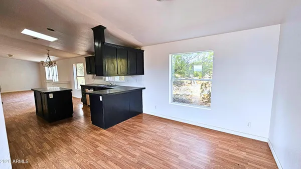 a kitchen with stainless steel appliances granite countertop a stove a sink a refrigerator and a window