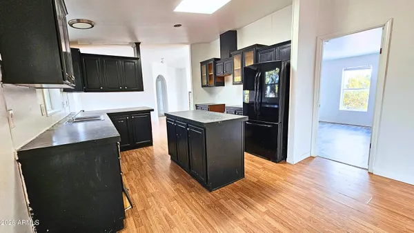 a kitchen with stainless steel appliances kitchen island granite countertop a stove and a refrigerator