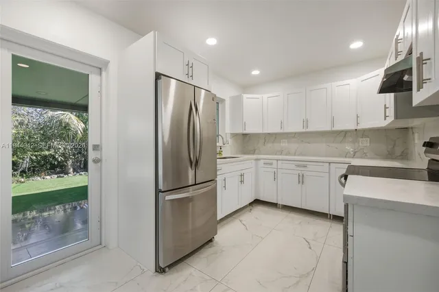 a kitchen with a refrigerator sink and cabinets