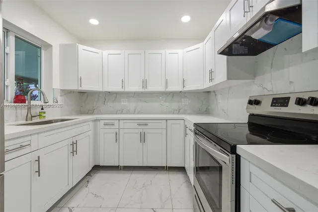 a kitchen with white cabinets and white appliances
