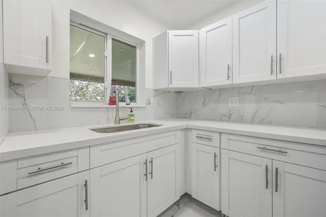 a kitchen with white cabinets and white appliances