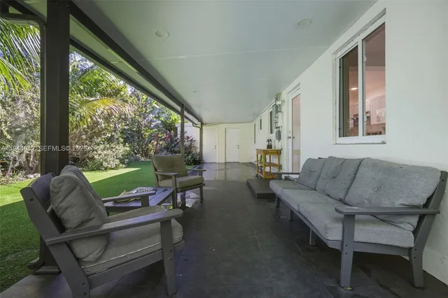 a living room with patio furniture and a floor to ceiling window