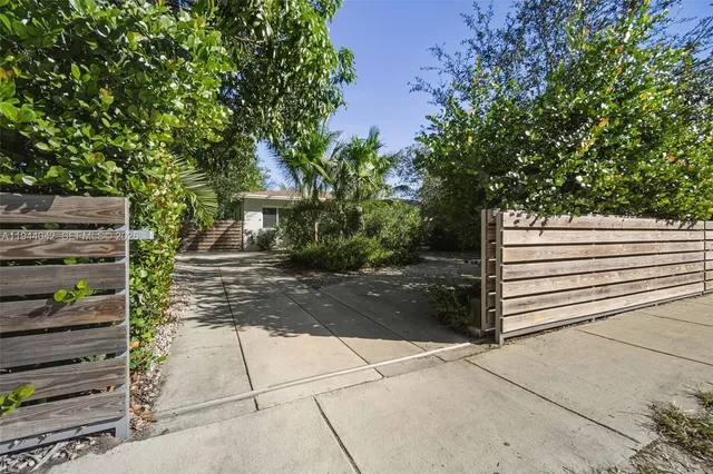 a view of a pathway with a bench in front of house