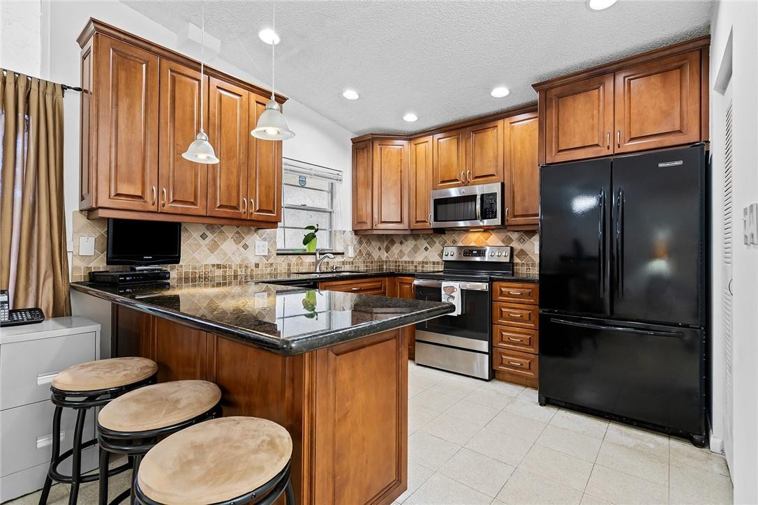 Undisclosed Address Boca Raton, FL 33428 - Photo 15 of 35 a kitchen with stainless steel appliances granite countertop a refrigerator a stove a sink and a microwave