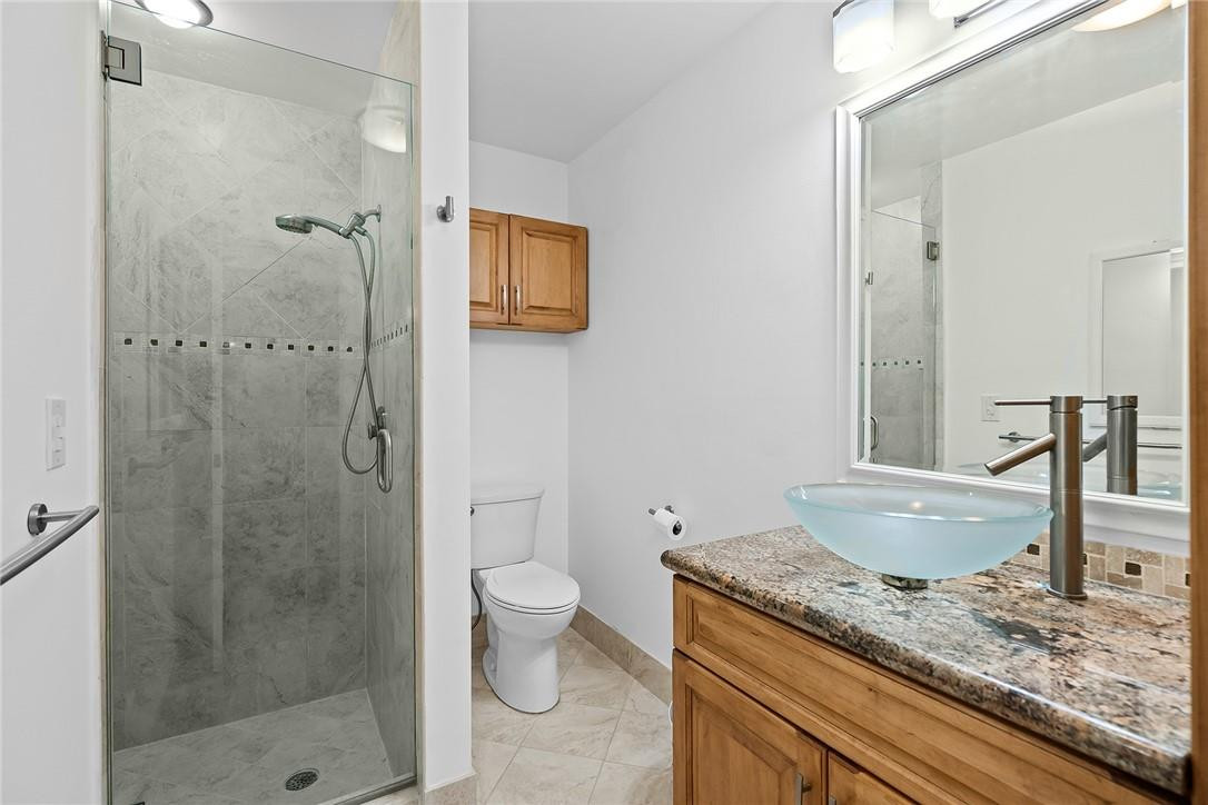 Undisclosed Address Boca Raton, FL 33428 - Photo 24 of 35 a bathroom with a granite countertop sink a toilet and shower
