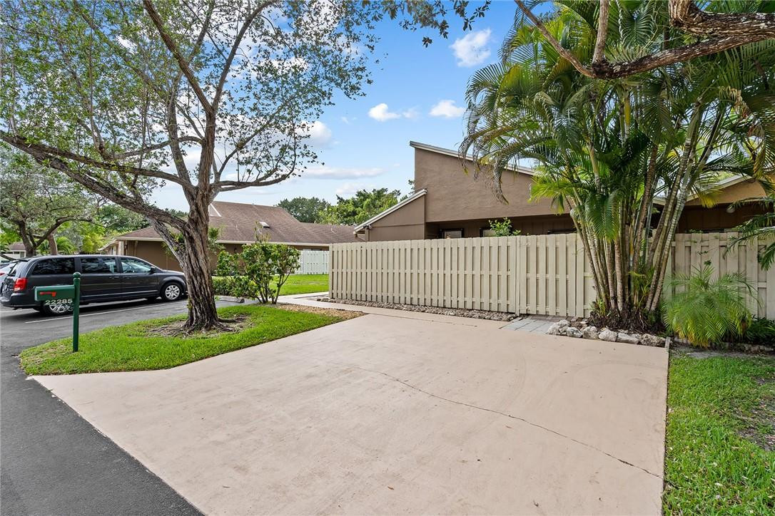 Undisclosed Address Boca Raton, FL 33428 - Photo 4 of 35 a view of a house with a yard and table and chairs under a large tree