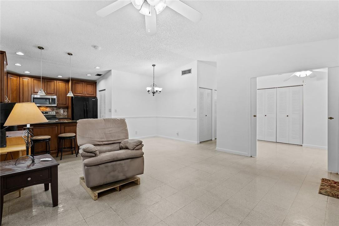 Undisclosed Address Boca Raton, FL 33428 - Photo 9 of 35 a living room with furniture and a chandelier
