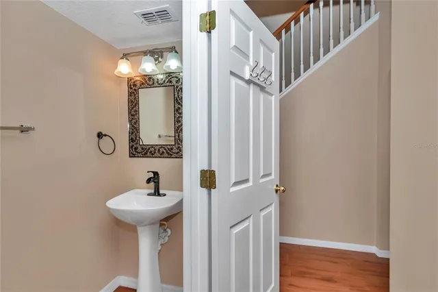 a view of a room with wooden floor and a ceiling fan