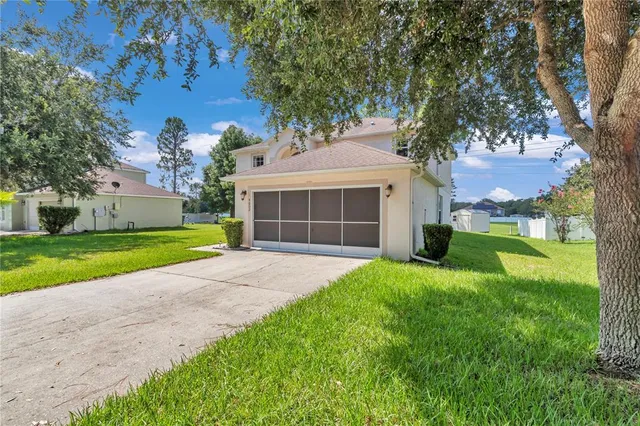 a aerial view of a house next to a yard with big trees
