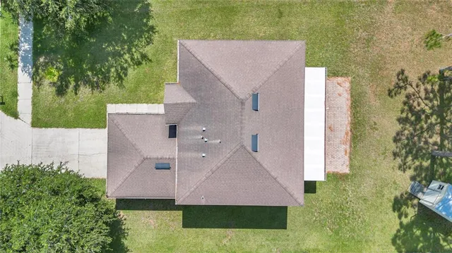 a view of a white house with a yard and plants