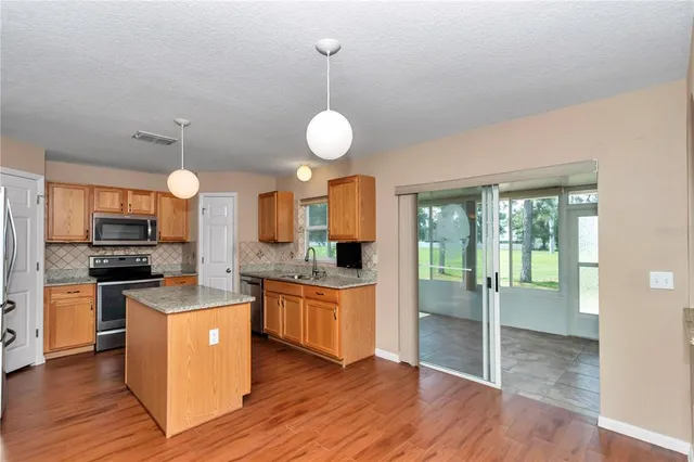 a kitchen with stainless steel appliances granite countertop wooden floors and sink