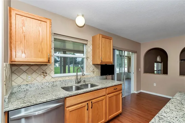 a kitchen with granite countertop a sink and a window