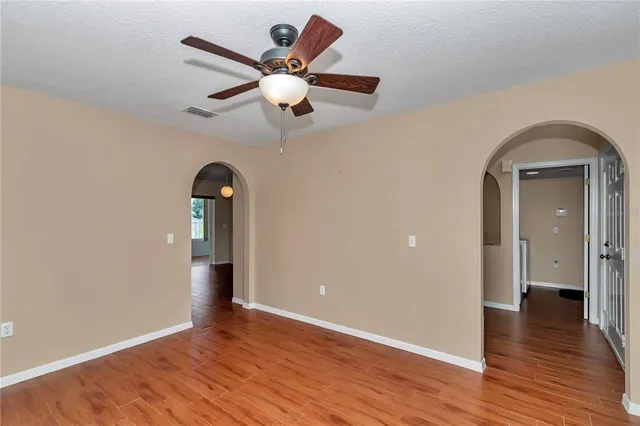 a view of a room with wooden floor and a ceiling fan