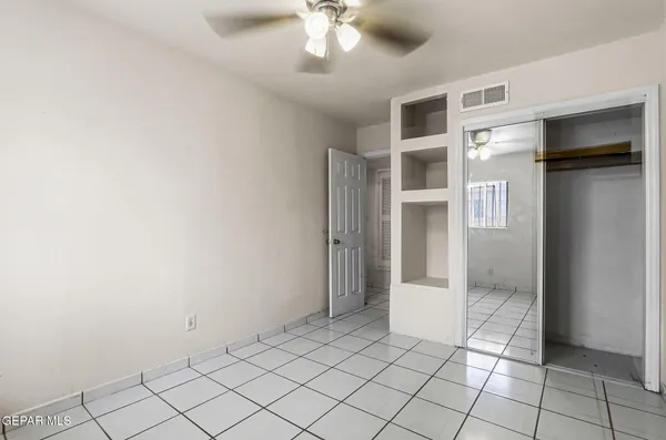 an empty room with windows and fan