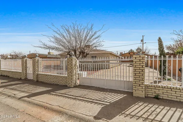 a view of a brick house with wooden fence