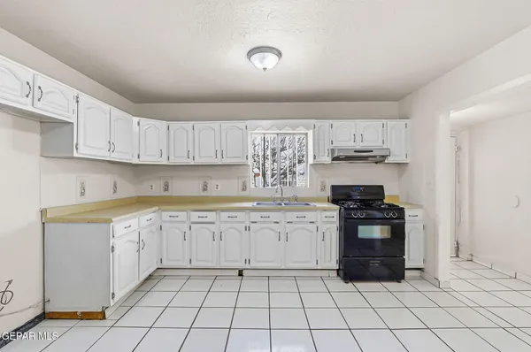 a kitchen with white cabinets and appliances