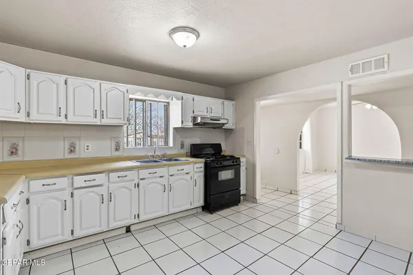 a view of a kitchen with white cabinets