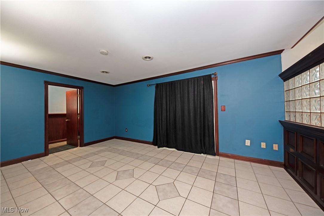 2501 East Pleasant Valley Road Independence, OH 44131 - Photo 13 of 29 Tiled family room featuring crown molding, access to a full bath and sliders to the sunroom