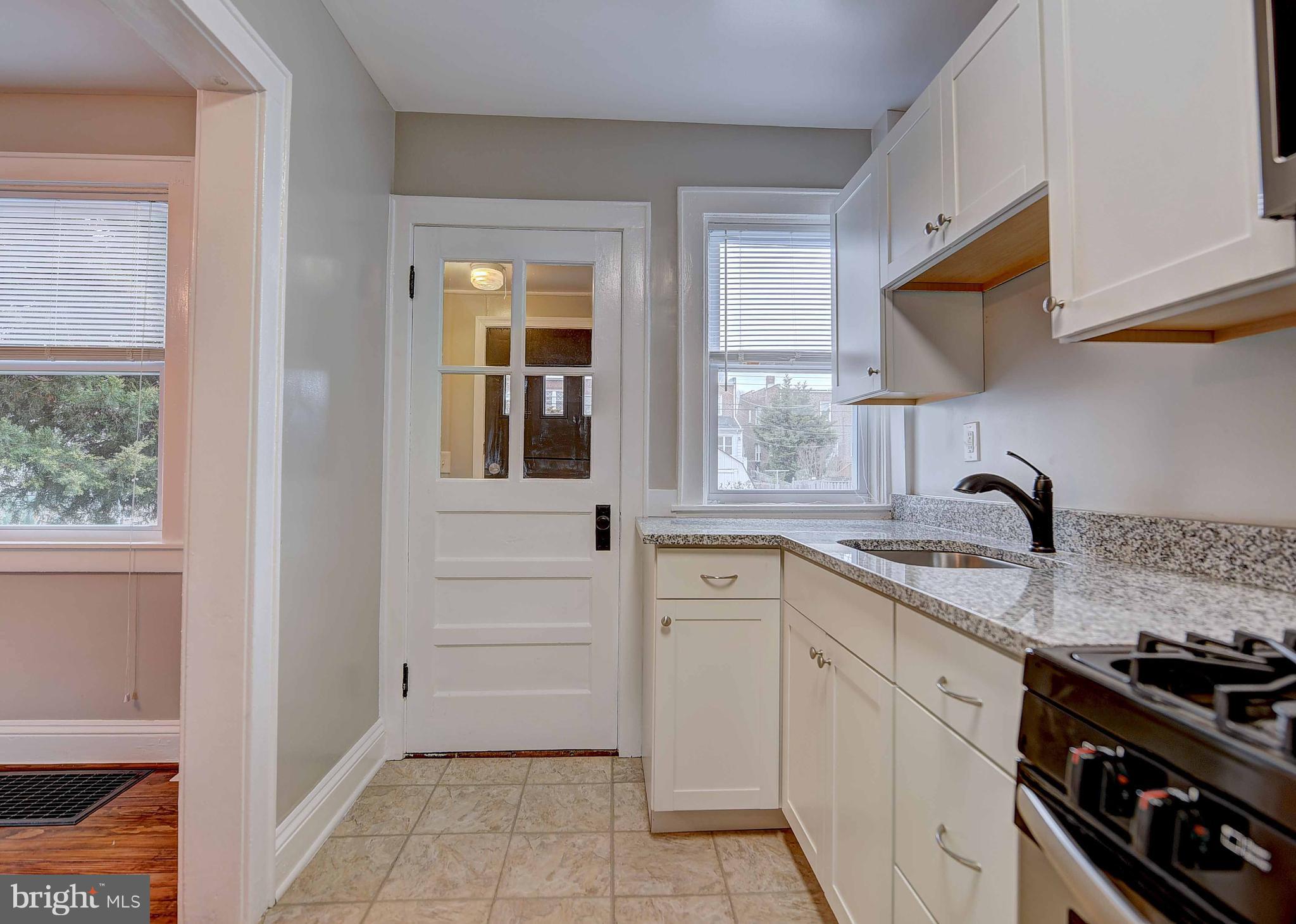 6830 Belclare Road Baltimore, MD 21222 - Photo 8 of 23 a kitchen with white cabinets and appliances