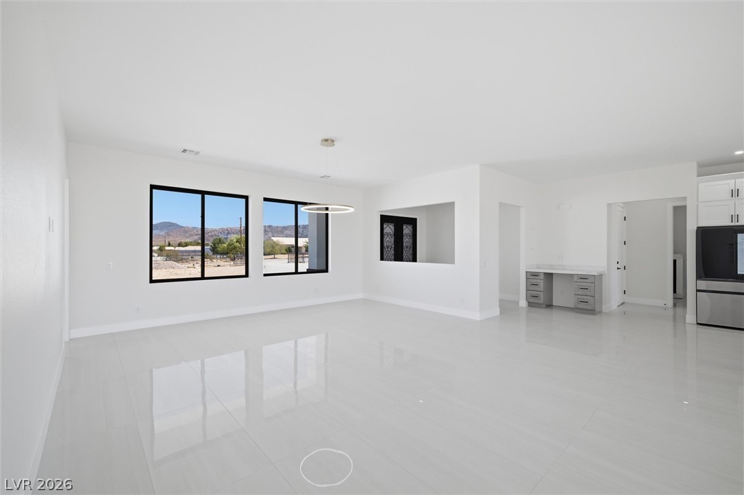 5910 East Kellogg Road Pahrump, NV 89061 - Photo 12 of 58 A luminous living space features gleaming tile flooring and expansive desert views.