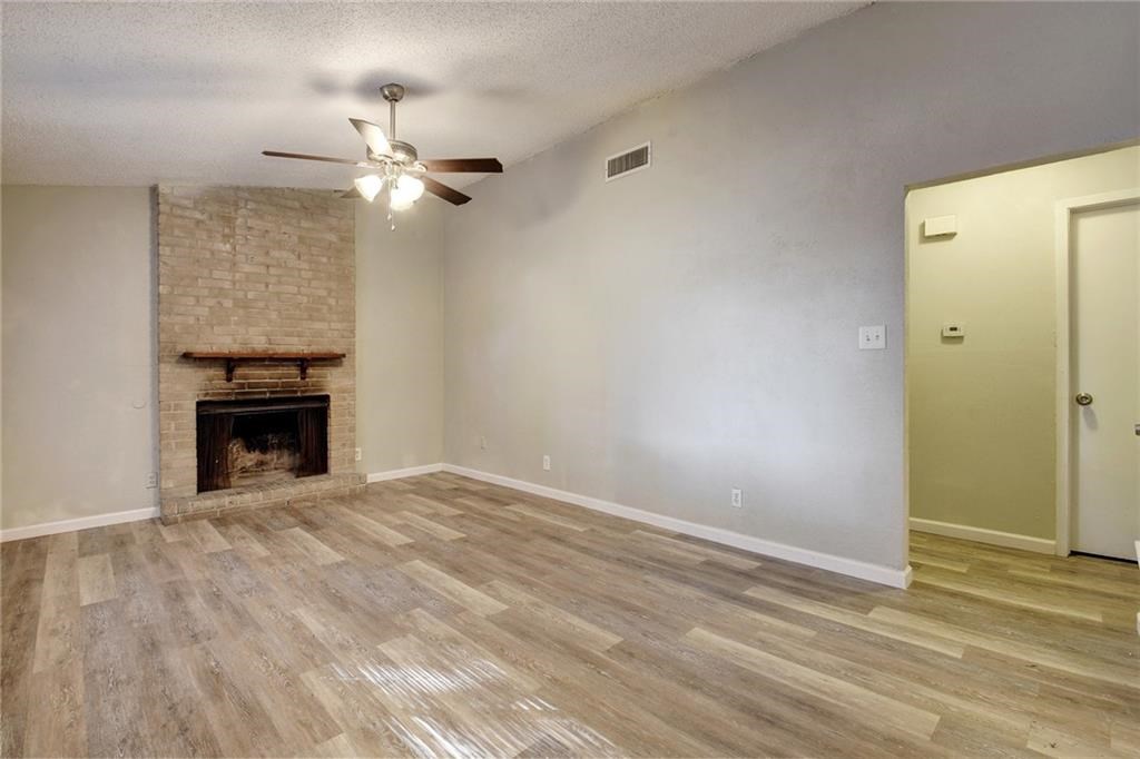 2311 Teri Road, Unit B Austin, TX 78744 - Photo 5 of 25 a view of empty room with ceiling fan and fireplace