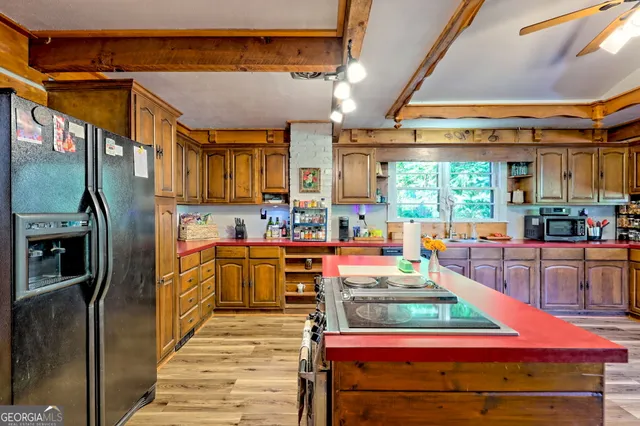 a view of an empty room with wooden floor and windows