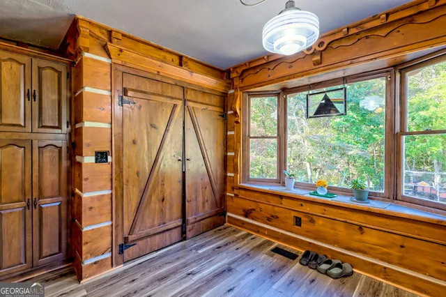 a view of a hallway with wooden floor and furniture