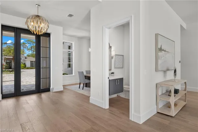 a view of a livingroom with wooden floor and a chandelier
