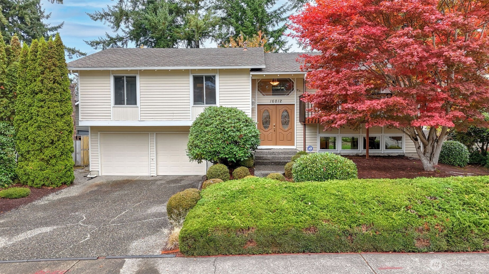 a front view of a house with a yard and garage