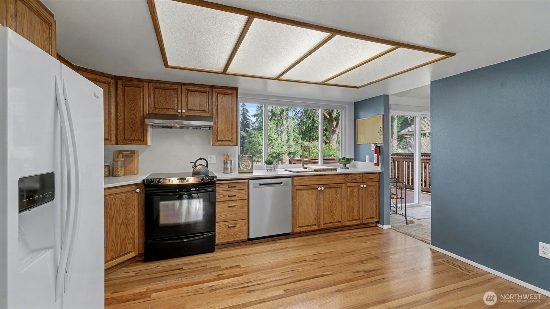 16012 Southeast 172nd Place Renton, WA 98058 - Photo 9 of 31 a kitchen with stainless steel appliances granite countertop a refrigerator a sink dishwasher a stove and white countertops with wooden floor