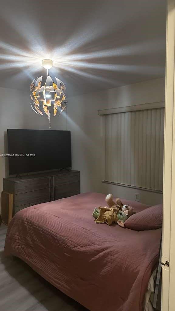 12415 Southwest 42nd Street Miramar, FL 33027 - Photo 17 of 50 a bedroom with a bed and a chandelier