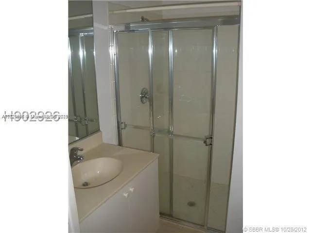 a bathroom with a sink mirror and shower
