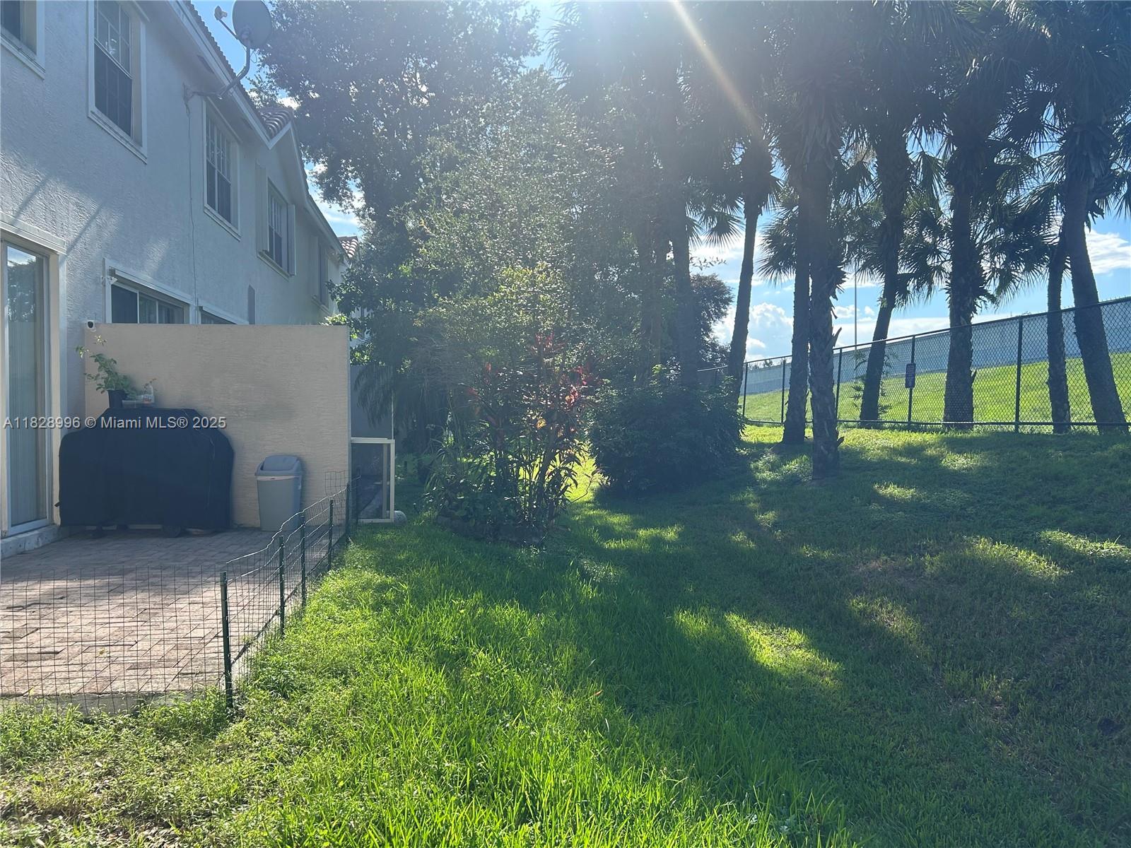 12415 Southwest 42nd Street Miramar, FL 33027 - Photo 34 of 50 a backyard of a house with lots of green space and fountain