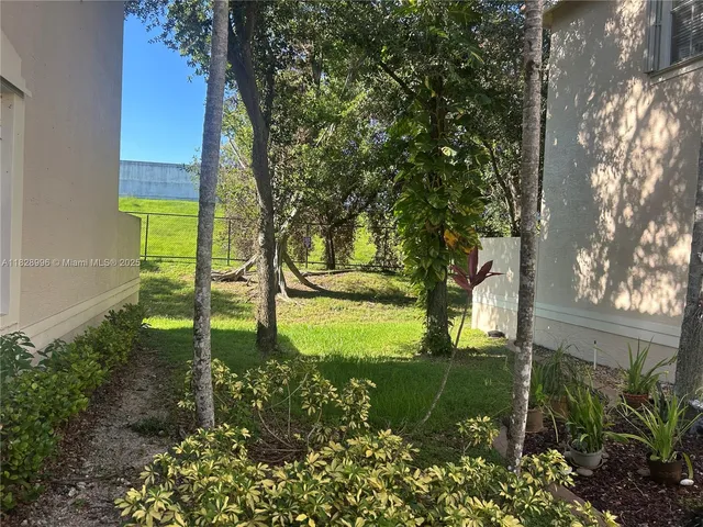 a front view of a house with a garden and trees