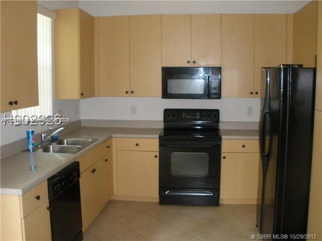 12415 Southwest 42nd Street Miramar, FL 33027 - Photo 7 of 50 a kitchen with a sink stove and refrigerator