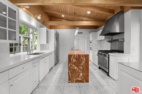 a kitchen with stainless steel appliances kitchen island granite countertop a sink a stove and cabinets