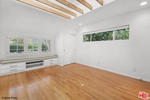 a view of a bedroom with wooden floor and a window
