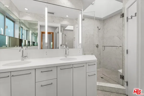a bathroom with a shower sink vanity granite and a mirror