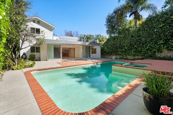 swimming pool view with a seating space and a garden view